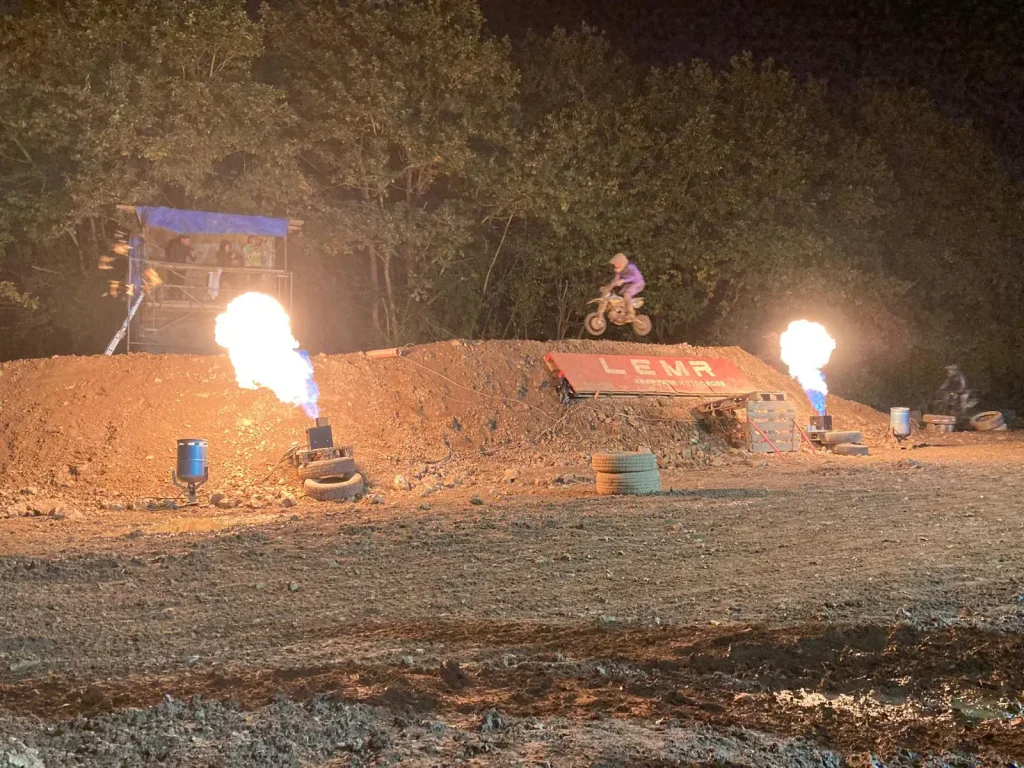 Saut sur table d'arrivée et flammes de nuit motocross